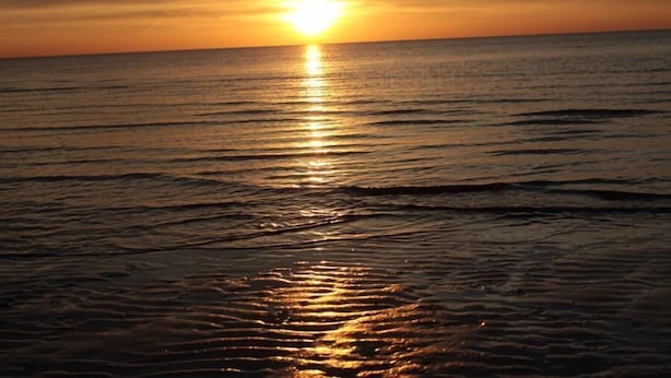 A sunset over a calm sea with gentle waves. - Haus Seewind 10 (Cuxhaven)