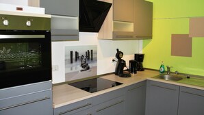 Une cuisine moderne équipée d’un four encastré, d’une machine à café et d’un évier.