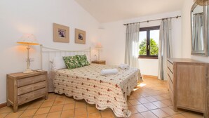 A bedroom with a bed, two bedside tables, a nightstand, a dresser, a window with curtains, and a wall-mounted mirror. - CAN MOLETA  Finca for 8 people near Porto Cristo (Manacor (Porto Cristo))