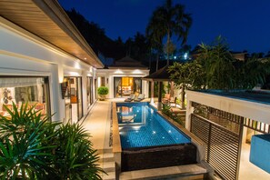 A modern house with a swimming pool, a covered patio, and a well-lit interior. - Tulip Pool Villa (Rawai)
