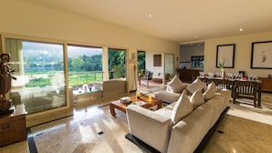 A spacious living room with a large sofa, a coffee table, and a dining area with a long table and chairs. - Viola Pool Villa (Rawai)