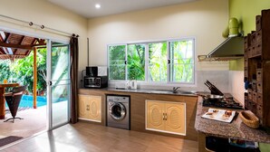Una cocina compacta con lavadora, microondas y estufa.
