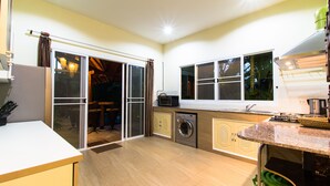 Una cocina compacta con lavadora integrada, microondas y pileta.