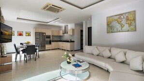 Un salon moderne comprenant un coin repas, une cuisine et une grande carte du monde accrochée au mur.