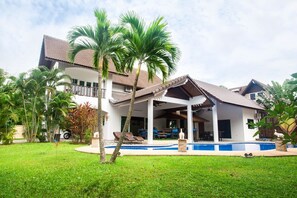 A two-story house with a swimming pool, surrounded by lush greenery and palm trees. - Twin Palm Pool Villa (Rawai)