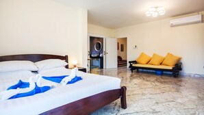 Una habitación de hotel con una cama, un sofá y un equipo de aire acondicionado.