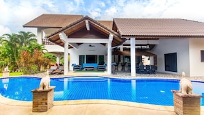 Un resort con piscina, mobiliario exterior y un patio cubierto.