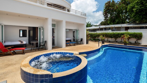 A modern hotel with a large outdoor swimming pool, a hot tub, and a covered seating area with lounge chairs. - Sky Pool Villa (Rawai)