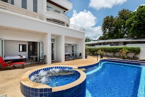 A modern hotel with a large outdoor swimming pool, a hot tub, and a covered seating area with lounge chairs. - Sky Pool Villa (Rawai)