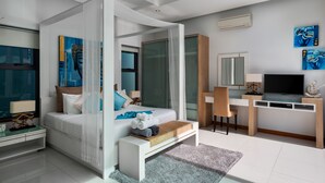 A modern bedroom with a bed, bedside table, TV, desk, and artwork. - Crystal Pool Villa (Rawai)