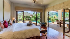 Ein geräumiges Schlafzimmer mit einem großen Bett, einem Nachttisch und Blick auf einen Pool und Garten.