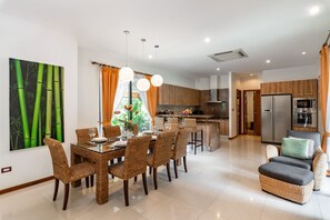 A modern kitchen with a central island, wooden cabinets, and stainless steel appliances.