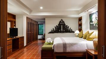 A bedroom with a bed, a television, a desk, and a wardrobe.