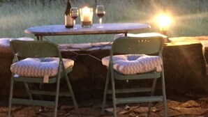 An outdoor dining area with a table and chairs, a bottle of wine, and candles. - Would you like to let your mind wander? Welcome to the Morvan Nature Park (Cussy-en-Morvan)