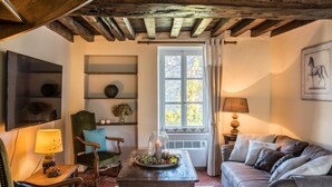 A cozy living room with a wooden ceiling, a fireplace, a comfortable sofa, a wooden coffee table, and a television. - Would you like to let your mind wander? Welcome to the Morvan Nature Park (Cussy-en-Morvan)