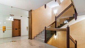 A modern interior with a staircase, glass doors, and a wooden door.