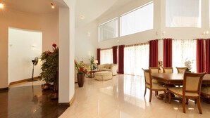 A spacious living area with a dining table, sofas, and a potted plant. - Villa 53 (Battaramulla)