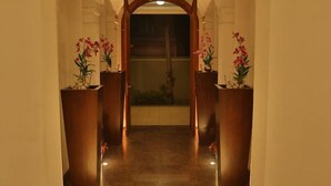 A hallway with marble flooring, wooden columns, and potted orchids. - Villa 53 (Battaramulla)