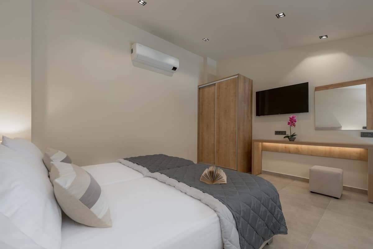 Una camera da letto moderna con un letto, un comodino e una TV a parete.