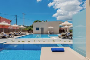 Een seizoensgebonden buitenzwembad, parasols voor strand/zwembad