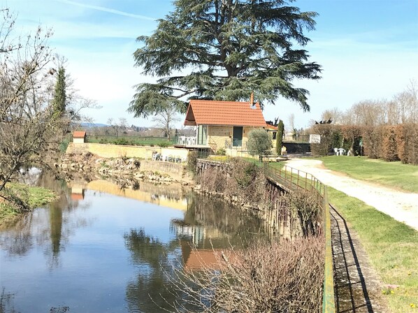 Situated lakeside, this serene residence offers a tranquil atmosphere with a lawn and pathway.
