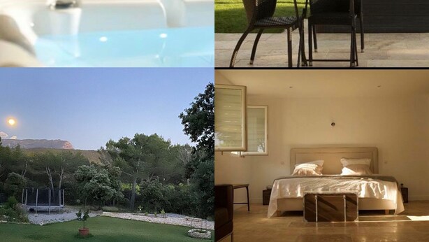 A bedroom with a bed, bedside table, and a view of a garden. - B&B Mas Lou Felibrige (Venelles)
