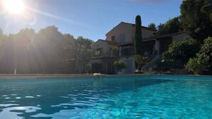 A clear swimming pool with a house in the background. - B&B Mas Lou Felibrige (Venelles)
