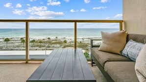 Een balkon met uitzicht op strand en zee.