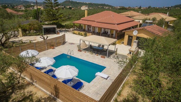 Una proprietà residenziale con piscina, area salotto esterna e portico coperto.