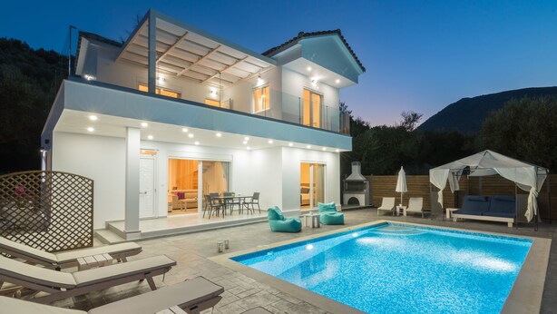 Une maison moderne à deux étages, dotée d’une piscine, d’un espace extérieur aménagé et d’un patio couvert.