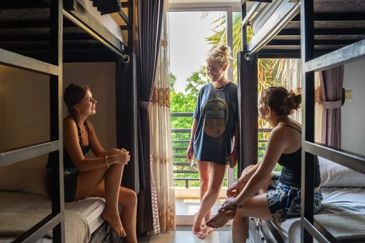 Un dormitorio con literas, una ventana con cortinas y vistas a zonas verdes.
