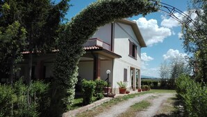 A two-story house with a gravel driveway and potted plants. - Agriturismo Il Punto Verde (Campagnatico)