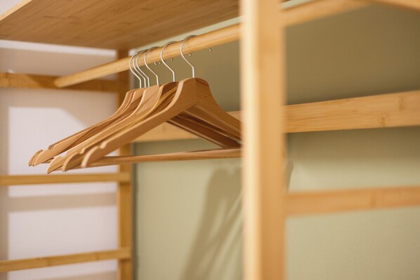 A wooden wardrobe with multiple shelves and hanging space.
