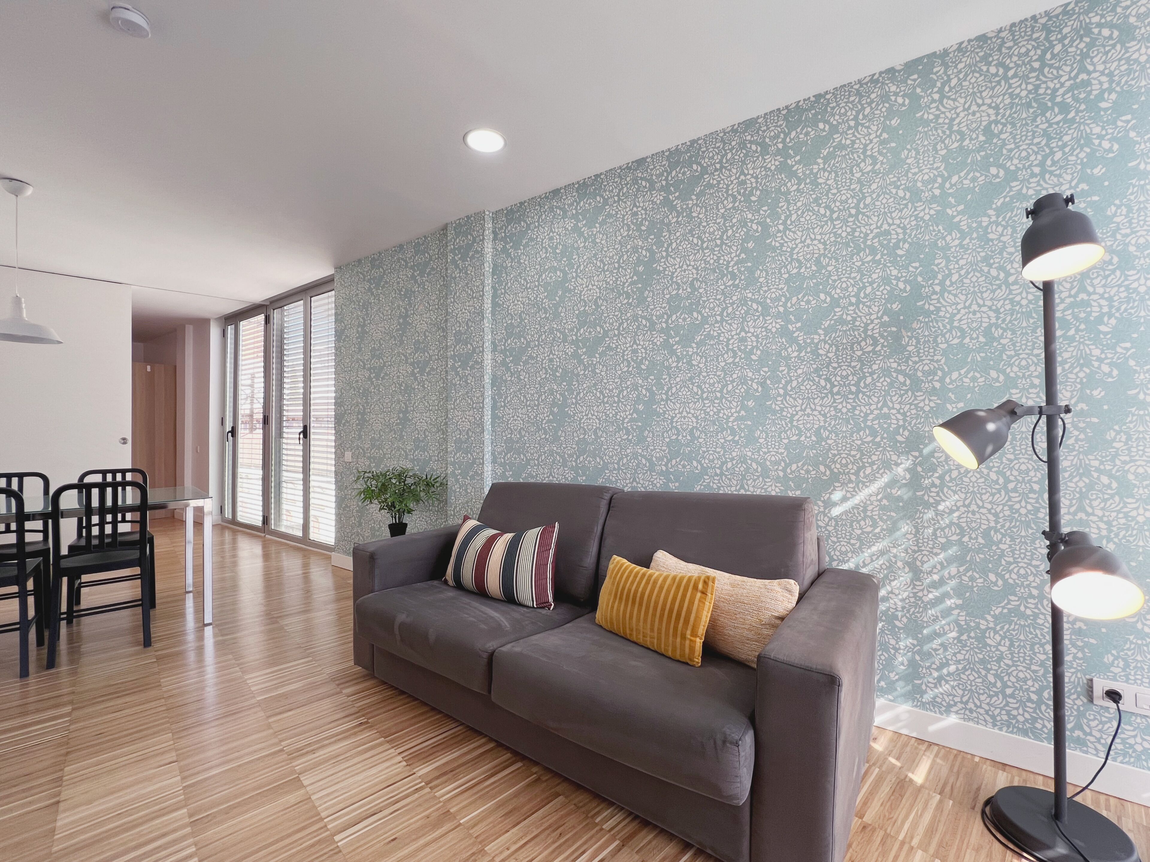 Una sala de estar moderna con un sofá gris, una mesita y sillas.