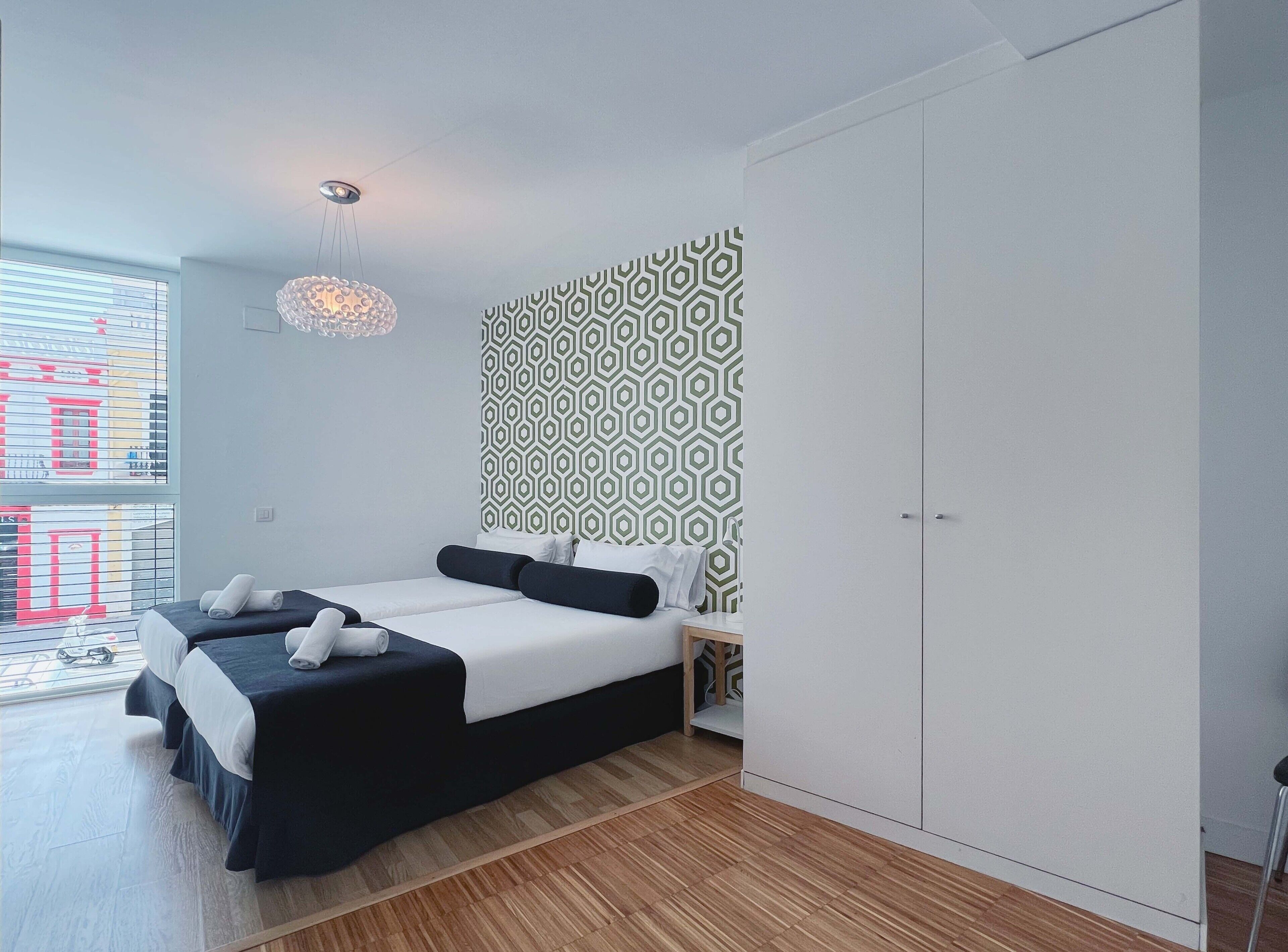 Ein modernes Schlafzimmer mit einem Bett, einem Kleiderschrank und einer Wand mit Muster.