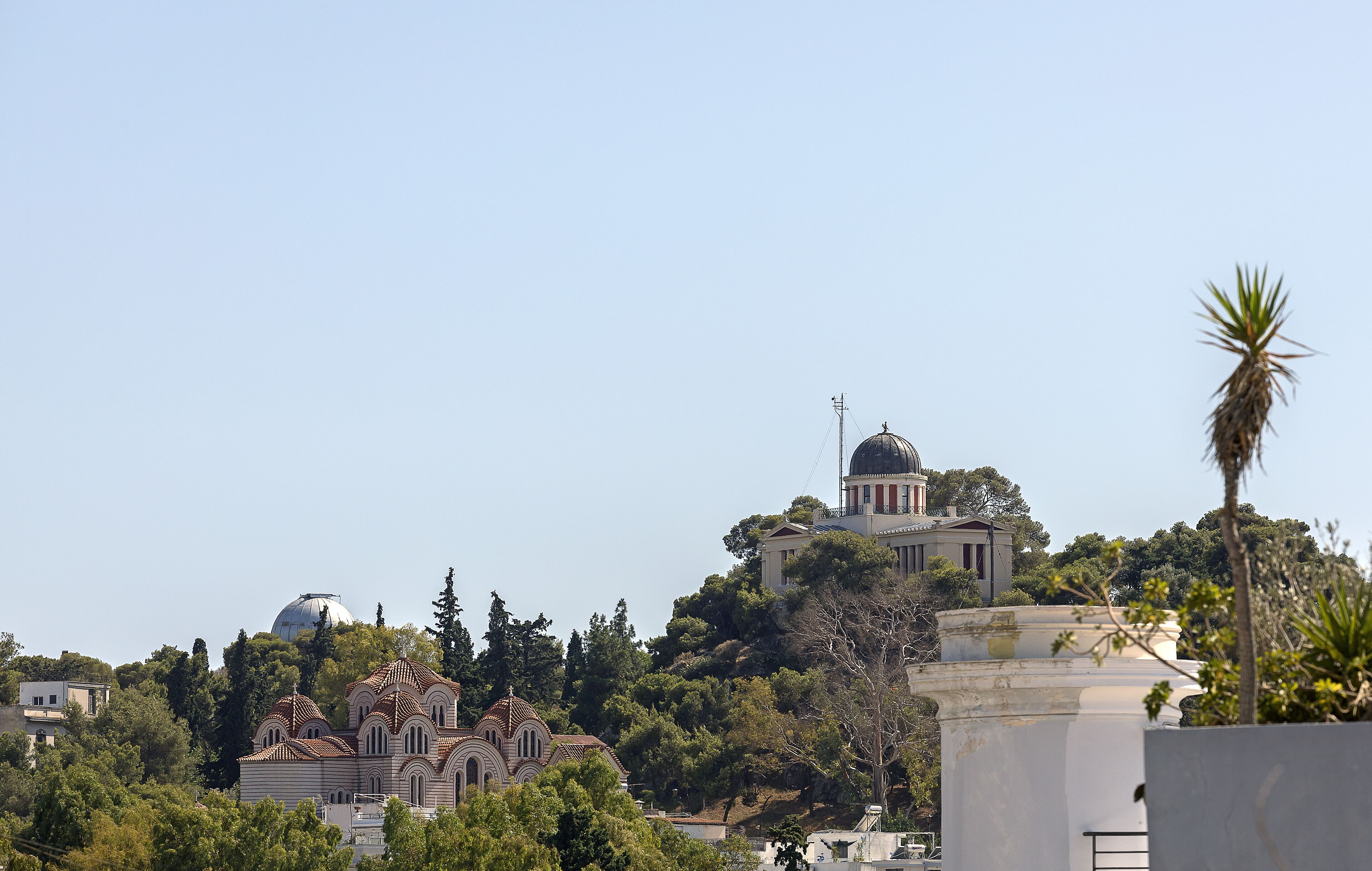 A church with a dome and bell tower, surrounded by trees and other buildings.