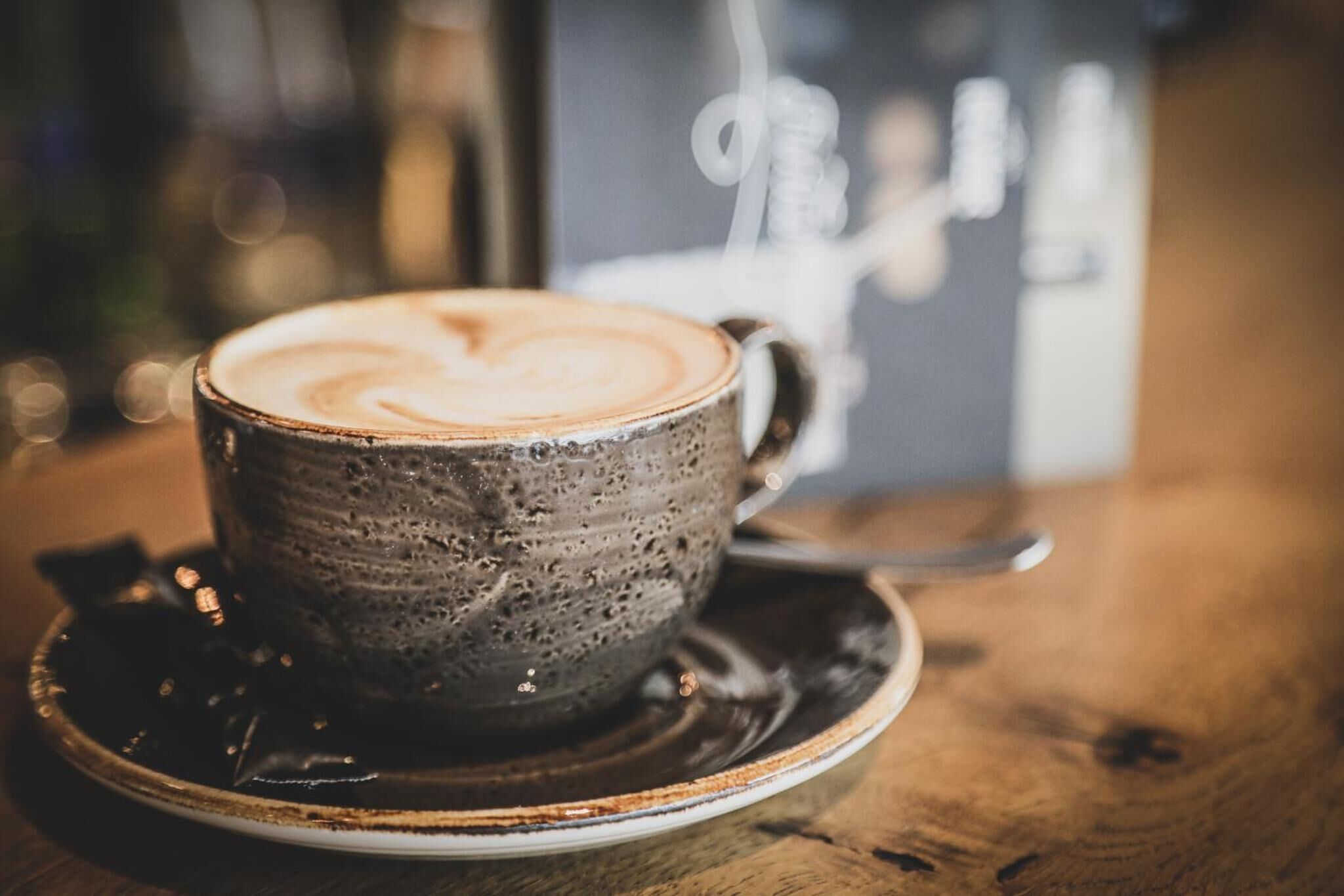 A cup of coffee with latte art on a saucer.