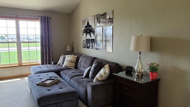 A living room with a sectional sofa, a small table, a lamp, and a potted plant. - Convenient to Green Bay's beltline where you can get anywhere in 15 minutes. (Green Bay)