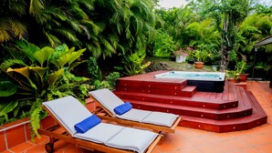A hot tub area with steps leading up to it, surrounded by lush greenery. - Nature Paradise Cottage • Lovers' Stay (Le Diamant)