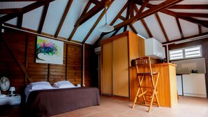 A bedroom with a bed, a desk, a chair, and a painting on the wall. - Nature Paradise Cottage • Lovers' Stay (Le Diamant)