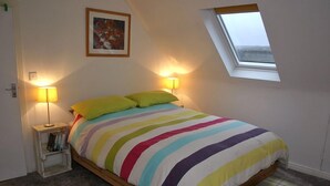 A bedroom with a bed, two bedside lamps, a small bedside table, a window, and a framed picture on the wall. - Great location to explore Connemara (Connemara)