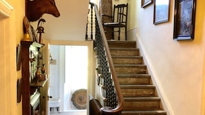 Eine Treppe mit Holzgeländer und schmiedeeisernem Geländer.