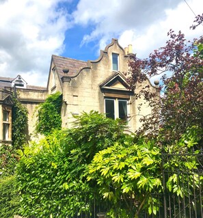 Un bâtiment historique en pierre, doté d’un toit à pignon remarquable et d’une grande fenêtre.