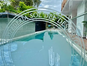 Una piscina con cerramiento de vidrio y un letrero que dice 'OSPEDERIA SOL DE DES'.