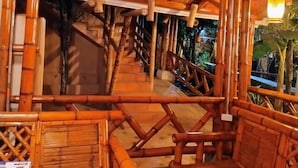 A bamboo-themed interior with a staircase and seating area. - Hospedería Sol Del Desierto - Hostel (Villavieja)