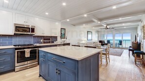 A modern kitchen with a central island, built-in oven, and microwave.