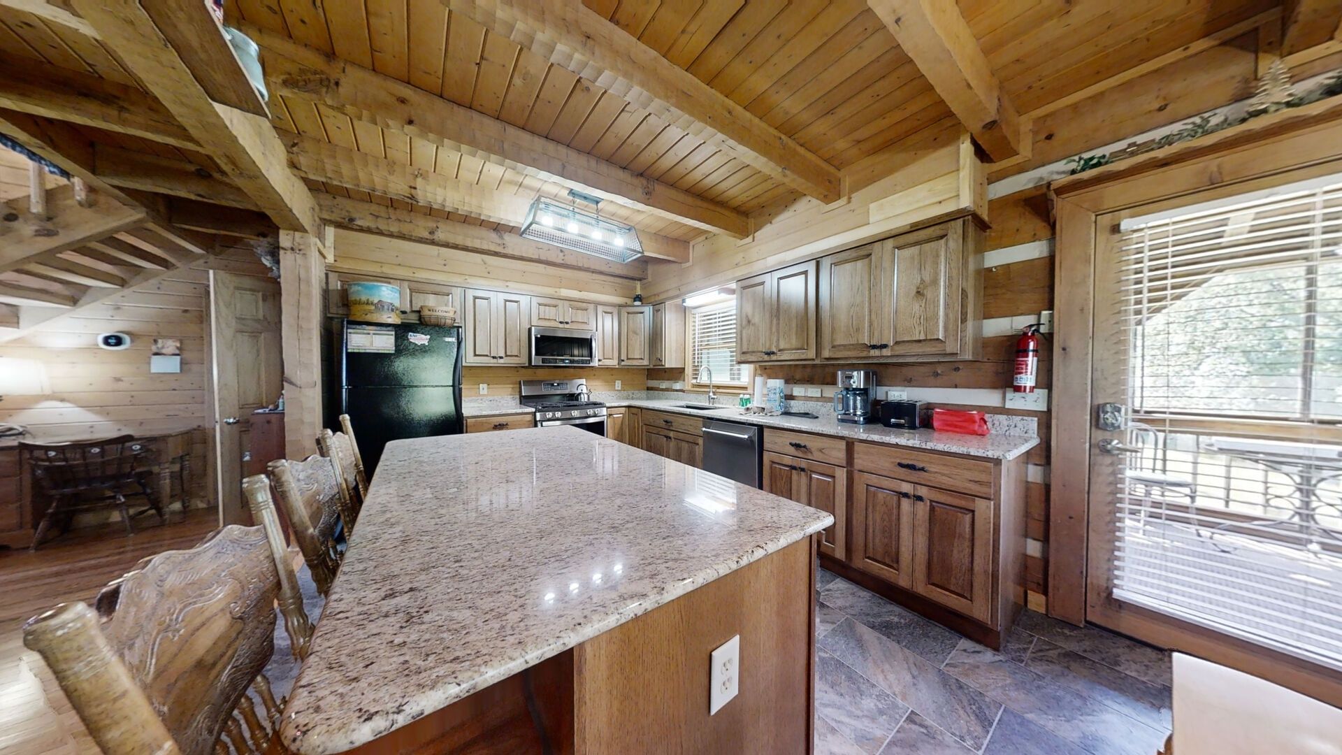 A spacious kitchen with wooden cabinets, granite countertops, and a large island.