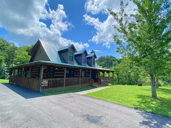 A log cabin with a porch, a covered deck, and a well-maintained lawn. - Dogwood Acre 3 Bedroom Cabin by RedAwning (Sevierville)