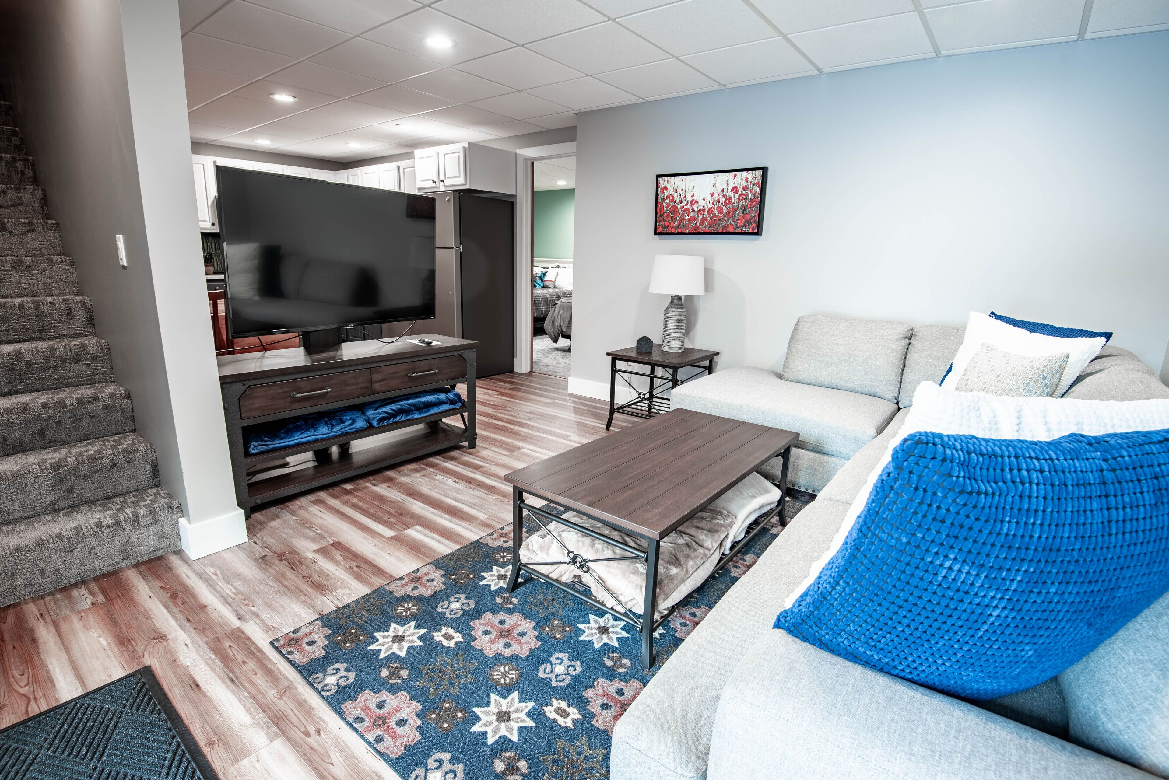 Un salon avec un canapé, une table basse, un téléviseur et un tapis à motifs.