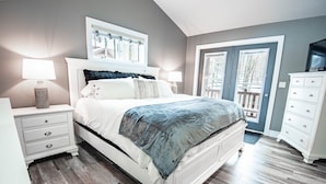 Une chambre à coucher avec un lit, des tables de chevet, une commode et un téléviseur.